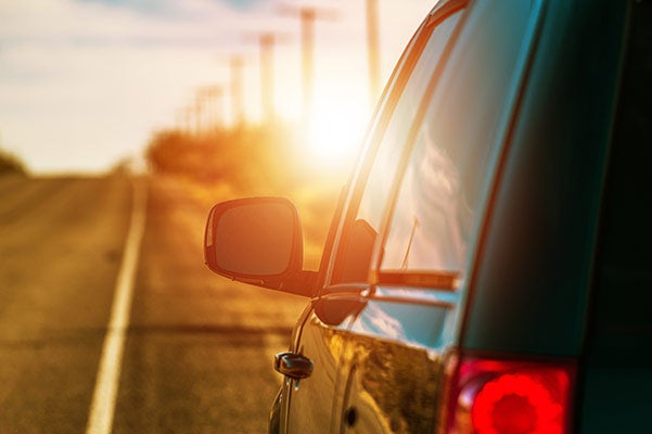 image of the side of a car with the sun in the background